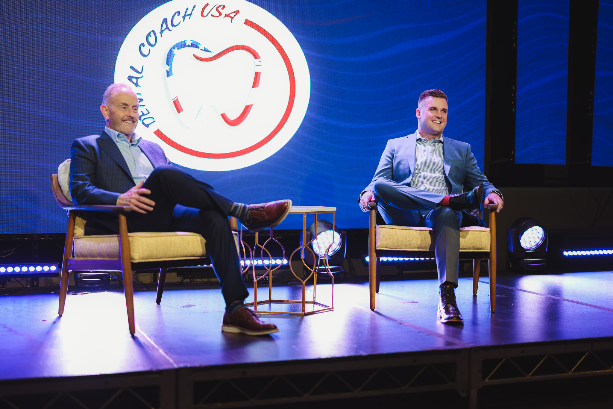 Dental Coach USA Experts - Dental Practice Valuation Two dental business consultants from Dental Coach USA sitting on stage discussing dental practice and ownership strategies - Dental Practice Valuation